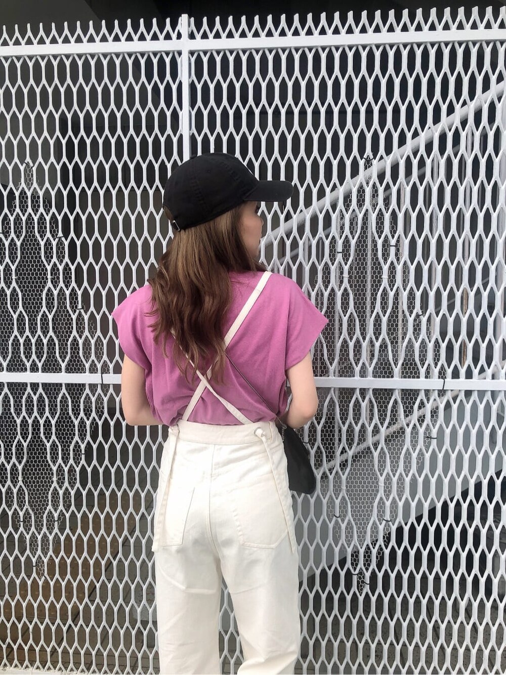 ピンク系のタンクトップ、ホワイト系のデニムパンツ、ブラック系のサンダルを着用したレディースの春コーディネートの5枚目の写真