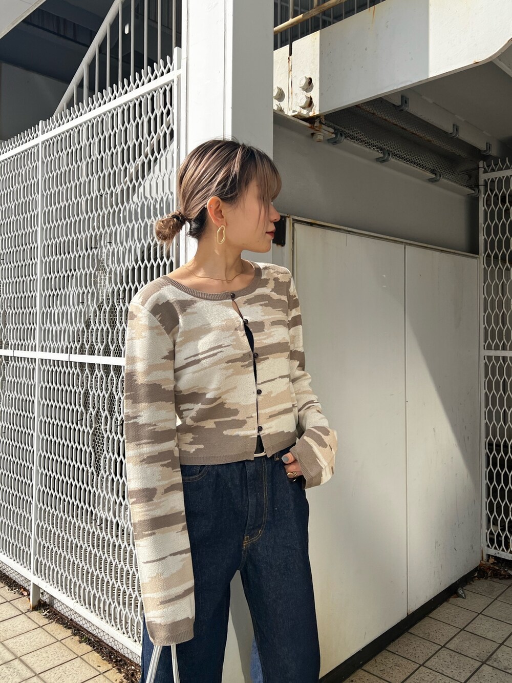 ブルー系のデニムパンツ、シルバー系のハンドバッグ、ベージュ系のカーディガン/ボレロを着用したレディースの冬コーディネートの5枚目の写真