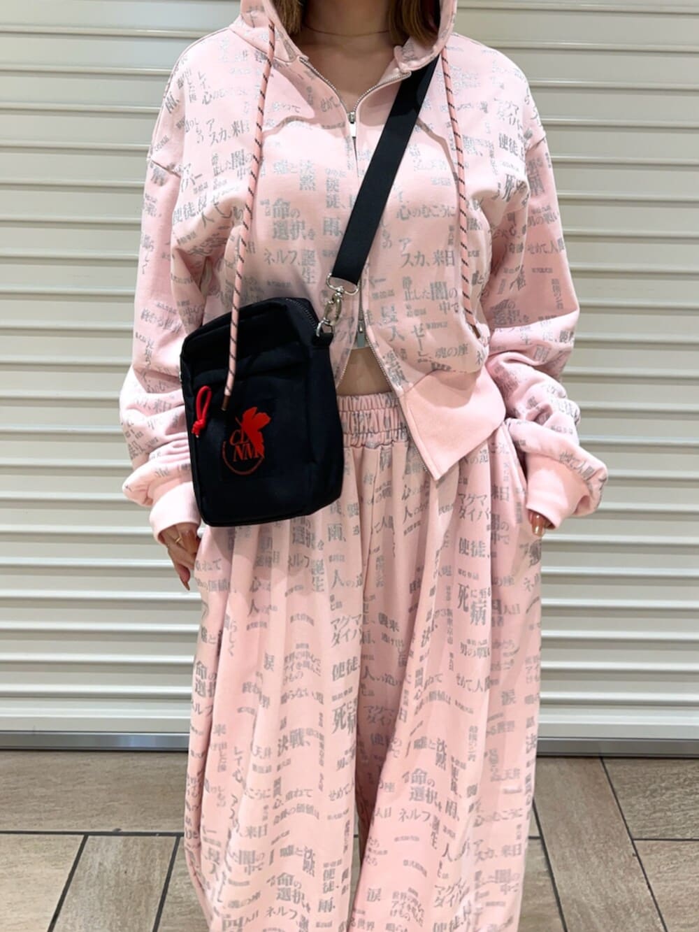 ピンク系のセットアップ、ブラック系のショルダーバッグを着用したレディースの春コーディネートの6枚目の写真