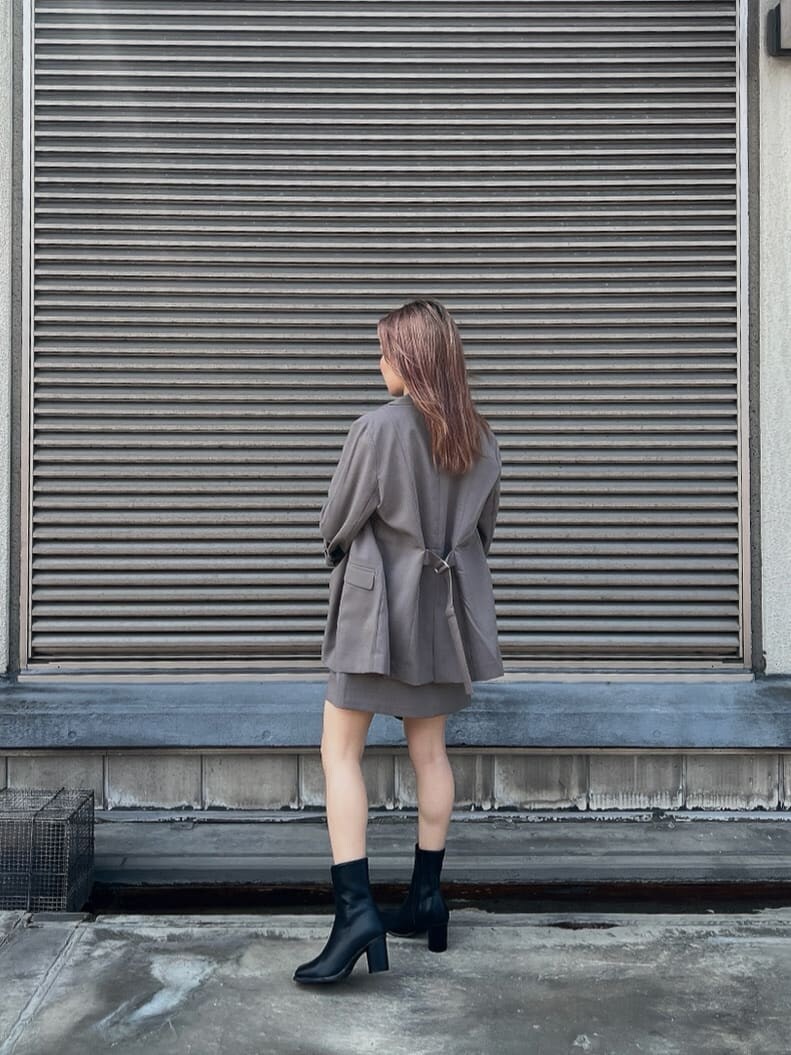 ホワイト系のタンクトップ、グレー系のテーラードジャケット、グレー系のスカートを着用したレディースの夏コーディネートの4枚目の写真