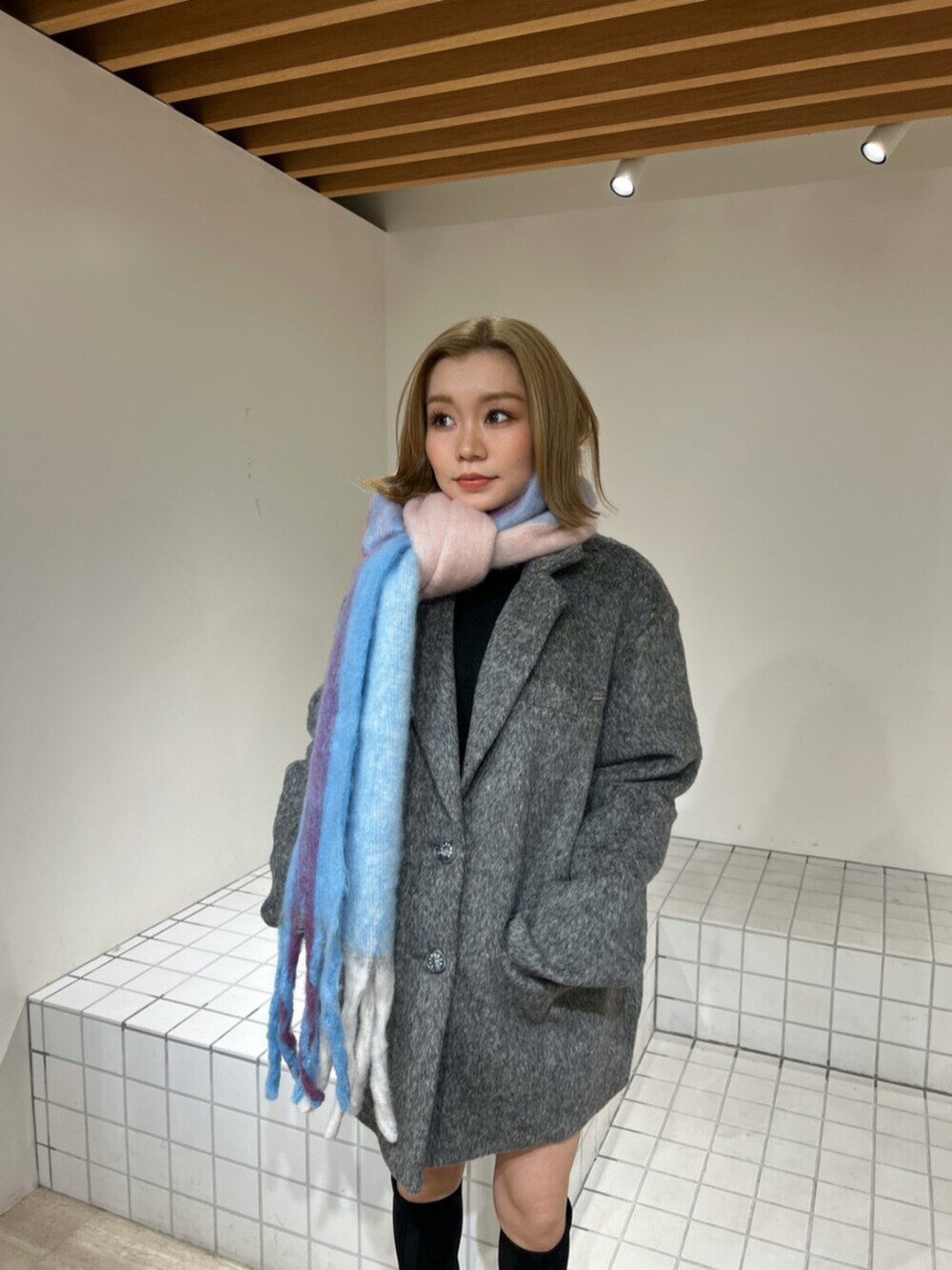 ブラック系のブーツ、グレー系のテーラードジャケット、その他のマフラーを着用したレディースの冬コーディネートの4枚目の写真