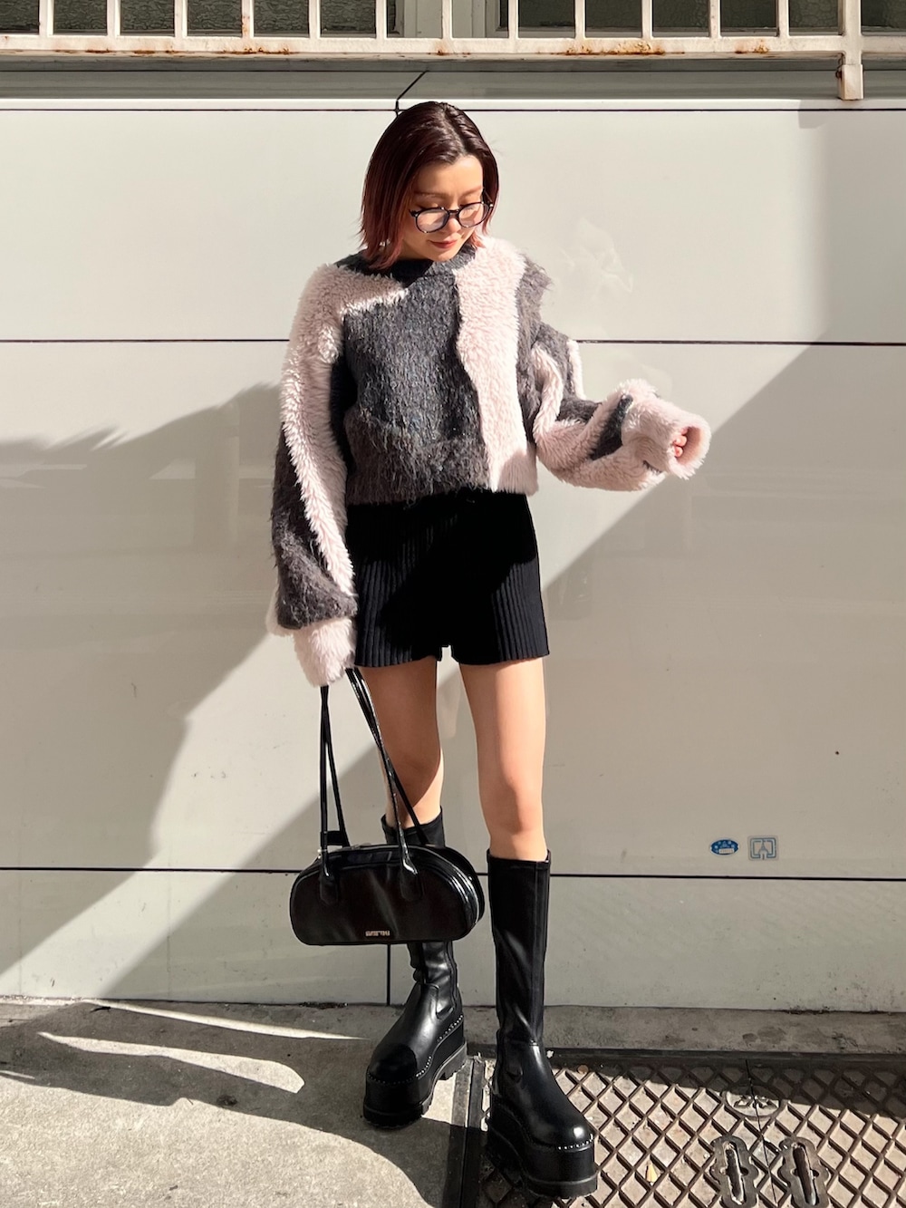 ブラック系のその他パンツ、ブラック系のボストンバッグ、ブラック系のブーツを着用したレディースの冬コーディネートの4枚目の写真