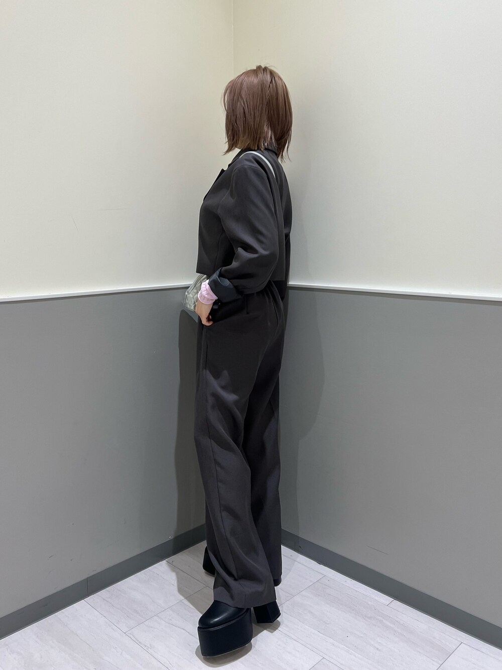 グレー系のテーラードジャケット、グレー系のその他パンツ、シルバー系のハンドバッグを着用したレディースの冬コーディネートの3枚目の写真