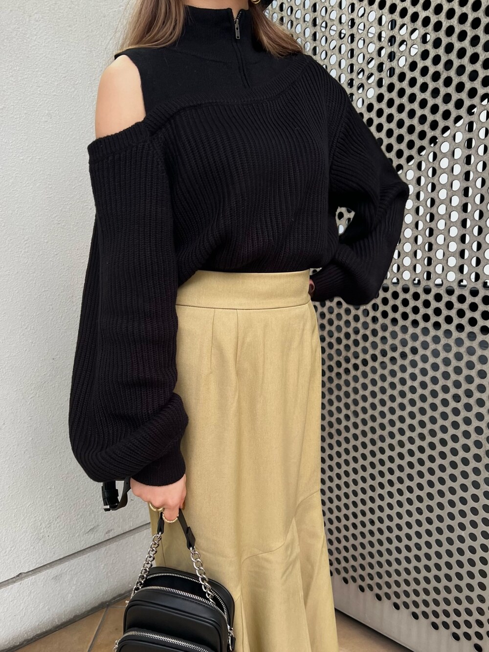 グリーン系のスカート、ブラック系のニット/セーター、ブラック系のショルダーバッグを着用したレディースの冬コーディネートの9枚目の写真