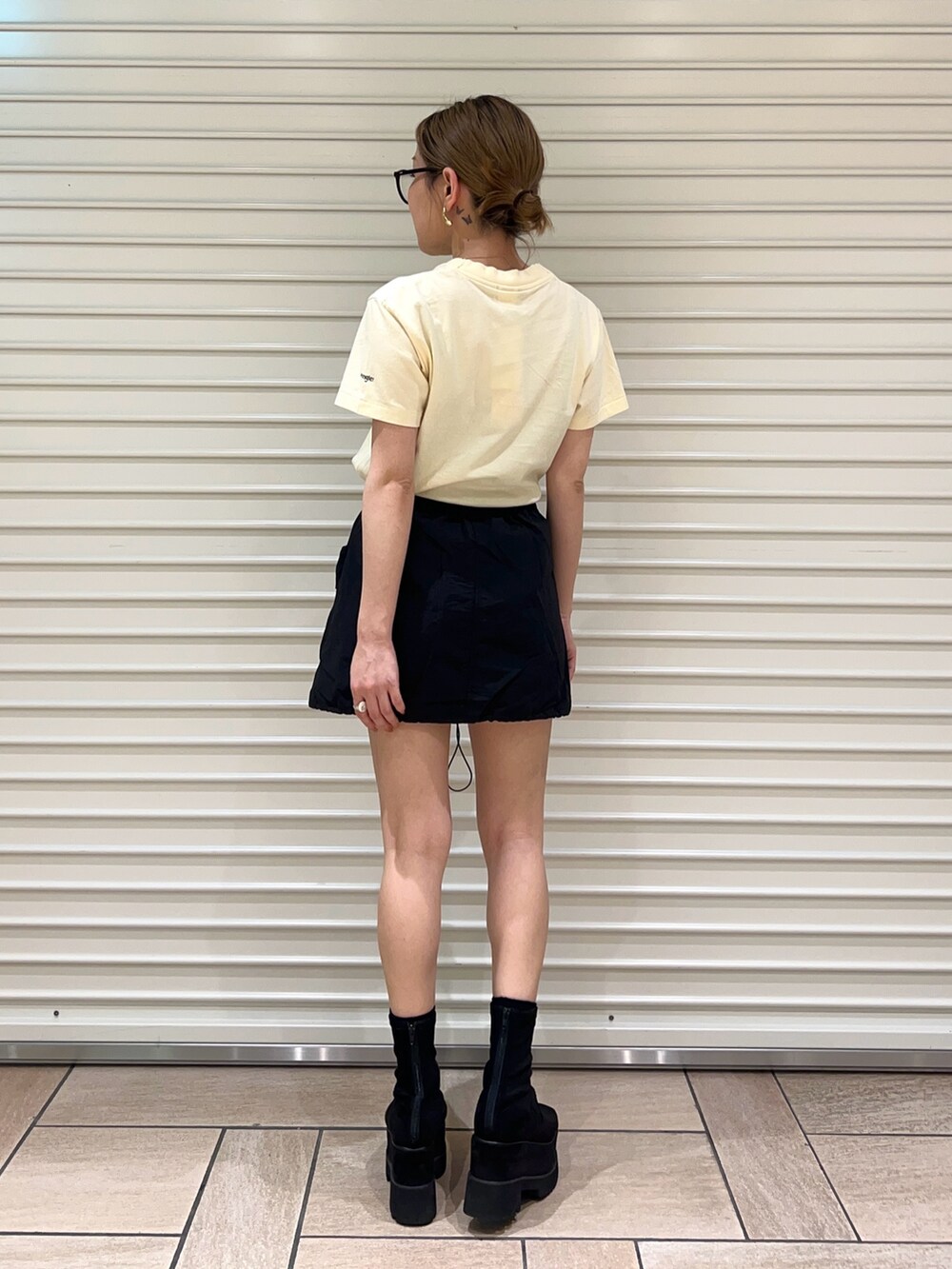 イエロー系のTシャツ/カットソー、ブラック系のスカートを着用したレディースの春コーディネートの3枚目の写真