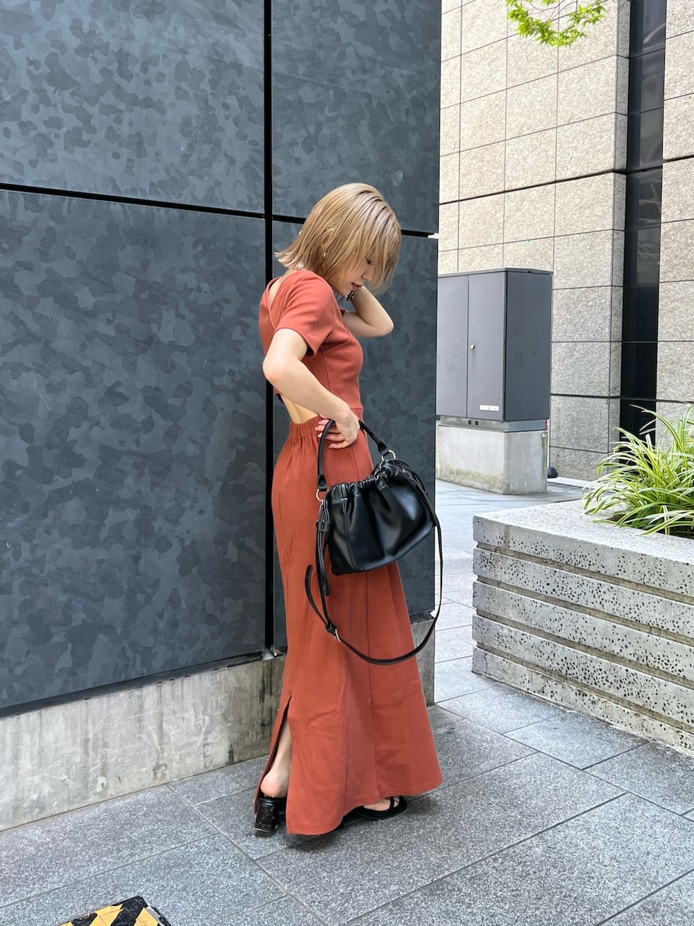 オレンジ系のワンピース、ブラック系のサンダルを着用したレディースの夏コーディネートの4枚目の写真