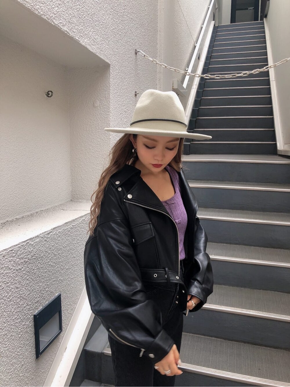 ホワイト系のブーツ、パープル系のニット/セーター、ブラック系のデニムパンツを着用したレディースの秋コーディネートの7枚目の写真