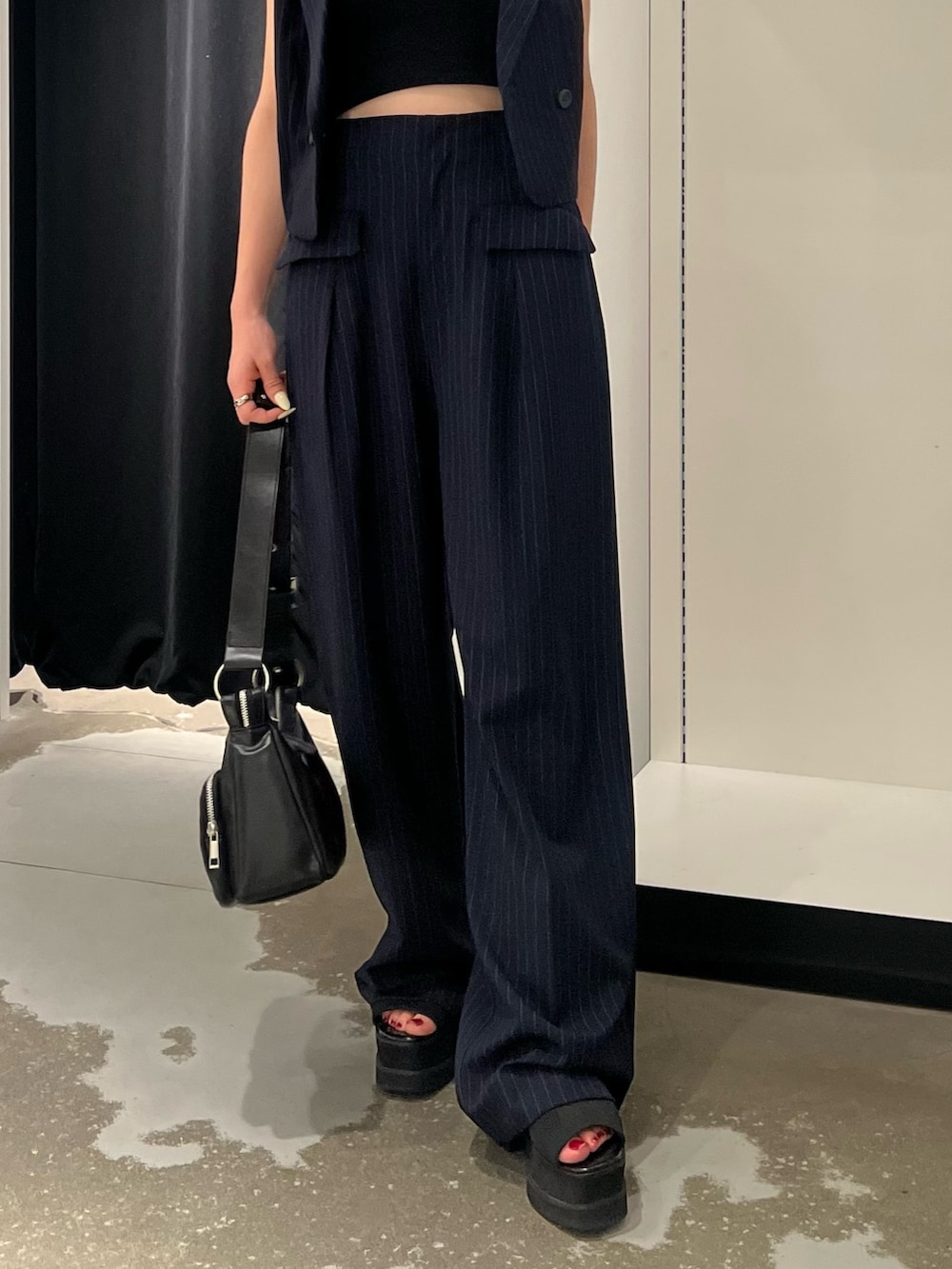 ブルー系のベスト、ブルー系のその他パンツ、ブラック系のキャミソールを着用したレディースの夏コーディネートの6枚目の写真