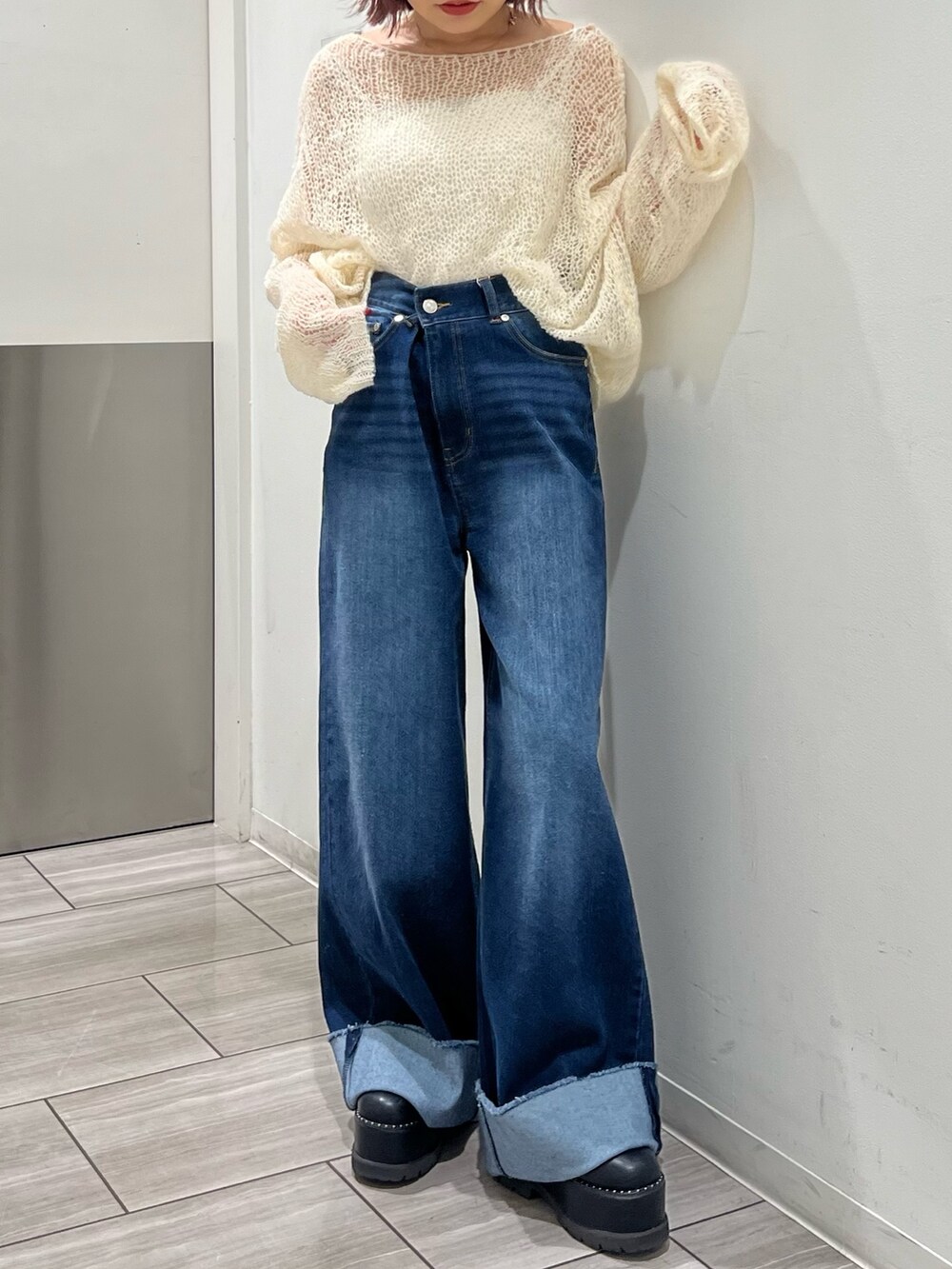 ブルー系のデニムパンツ、ホワイト系のニット/セーターを着用したレディースの秋コーディネートの4枚目の写真