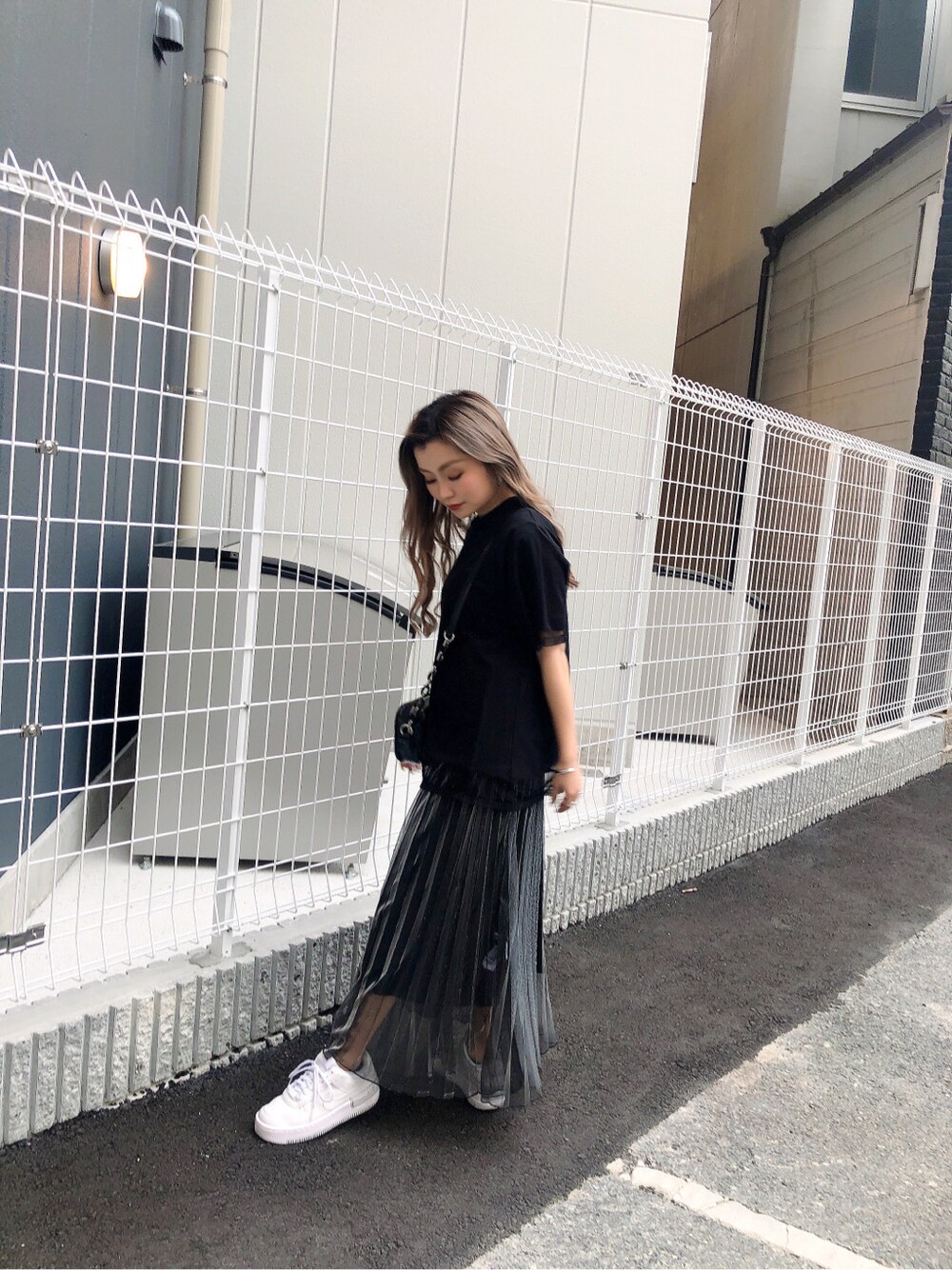 ブラック系のショルダーバッグ、ブラック系のスカート、ブラック系のTシャツ/カットソーを着用したレディースの春コーディネートの4枚目の写真