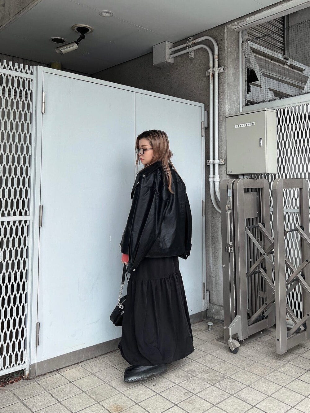 ブラック系のスカート、ブラック系のショルダーバッグ、ピンク系のニット/セーターを着用したレディースの秋コーディネートの2枚目の写真