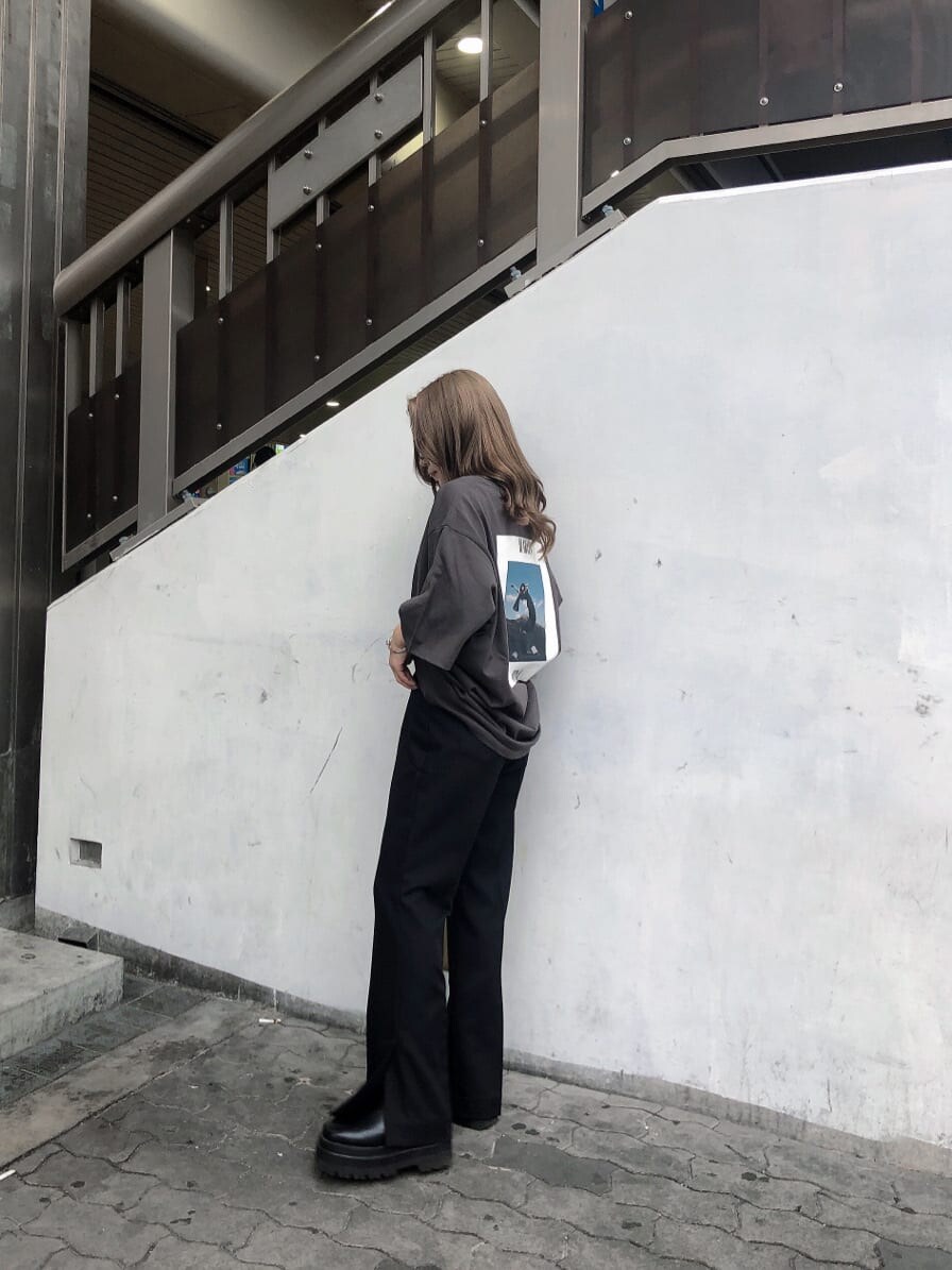 ブラック系のスラックス、ホワイト系のハンドバッグ、グレー系のTシャツ/カットソーを着用したレディースの春コーディネートの3枚目の写真