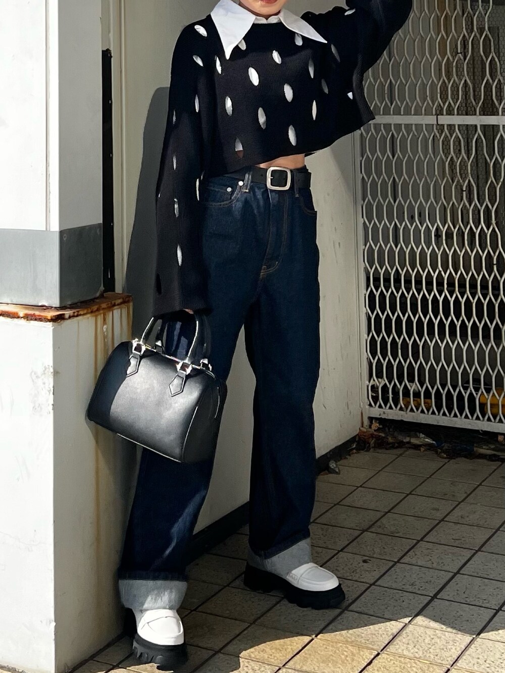 ブルー系のデニムパンツ、ホワイト系のローファー、ブラック系のニット/セーターを着用したレディースの冬コーディネートの4枚目の写真
