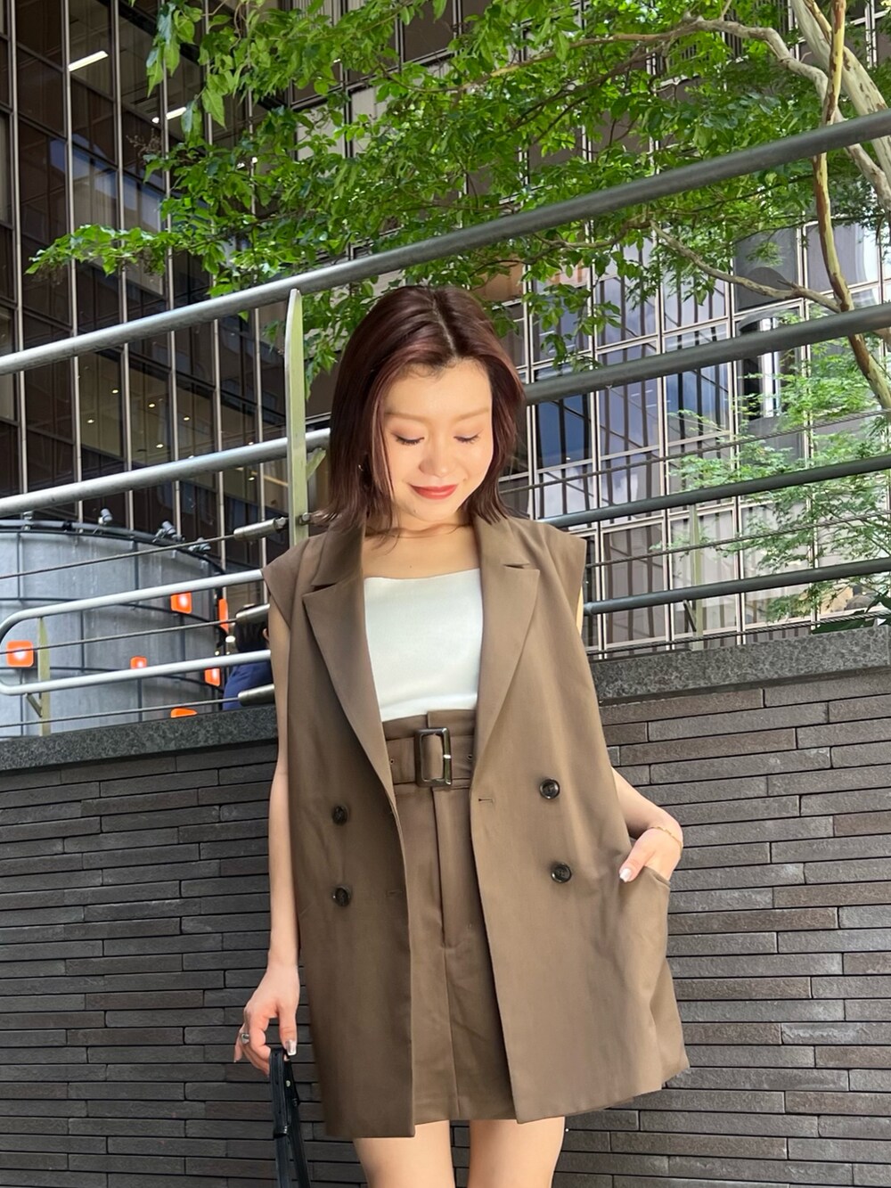 ブラウン系のベスト、ブラウン系のスカート、ホワイト系のニット/セーターを着用したレディースの夏コーディネートの5枚目の写真