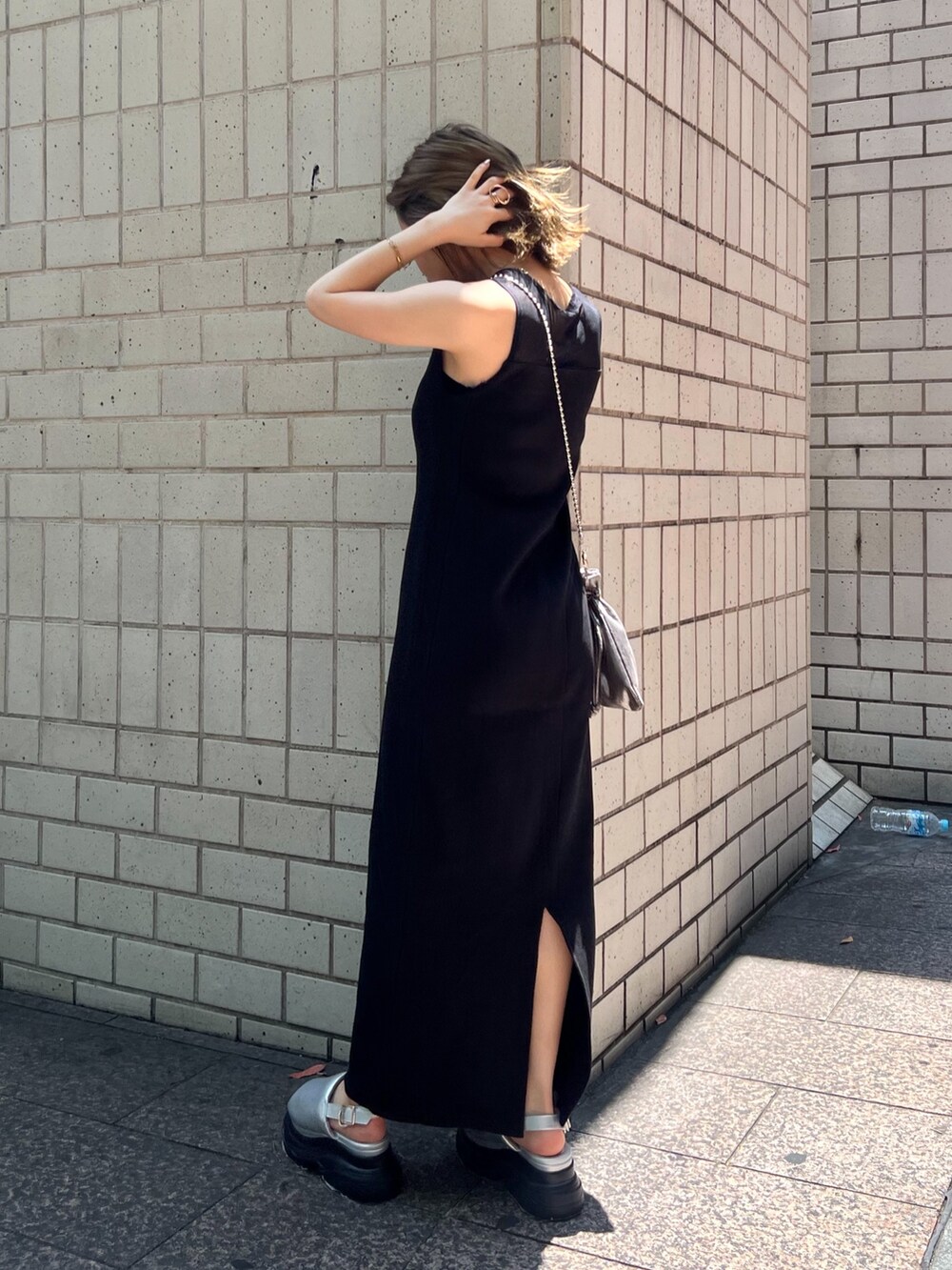 ブラック系のワンピース、シルバー系のサンダル、ブラック系のショルダーバッグを着用したレディースの夏コーディネートの5枚目の写真