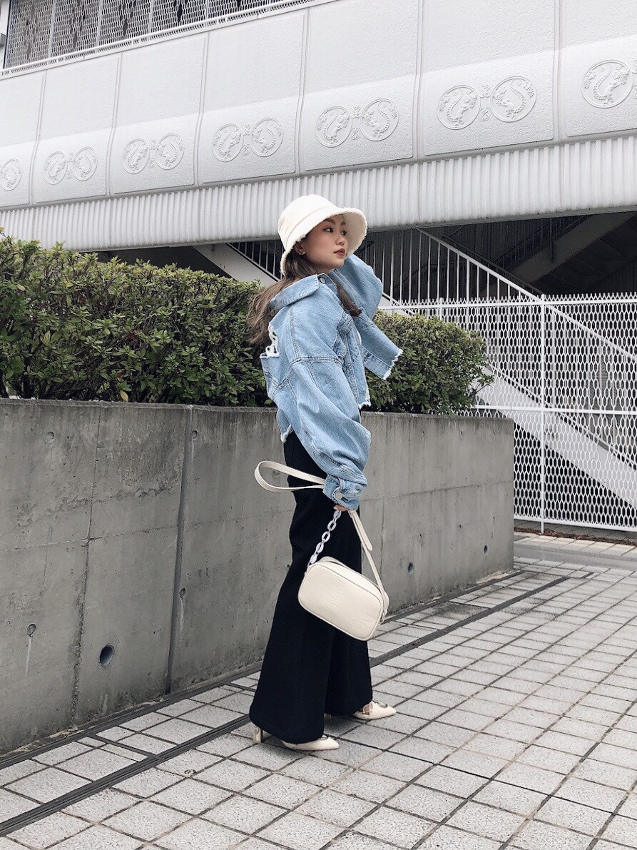 ブラック系のその他パンツ、ホワイト系のショルダーバッグ、ホワイト系のニット/セーターを着用したレディースの春コーディネートの2枚目の写真