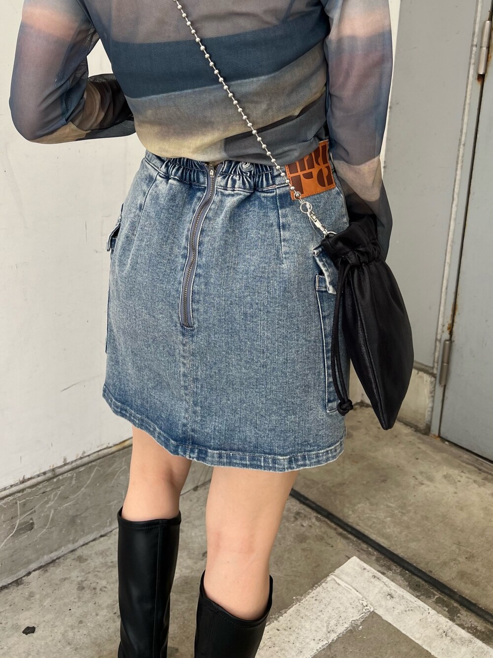 その他のTシャツ/カットソー、ブルー系のスカート、ブラック系のブーツを着用したレディースの夏コーディネートの7枚目の写真