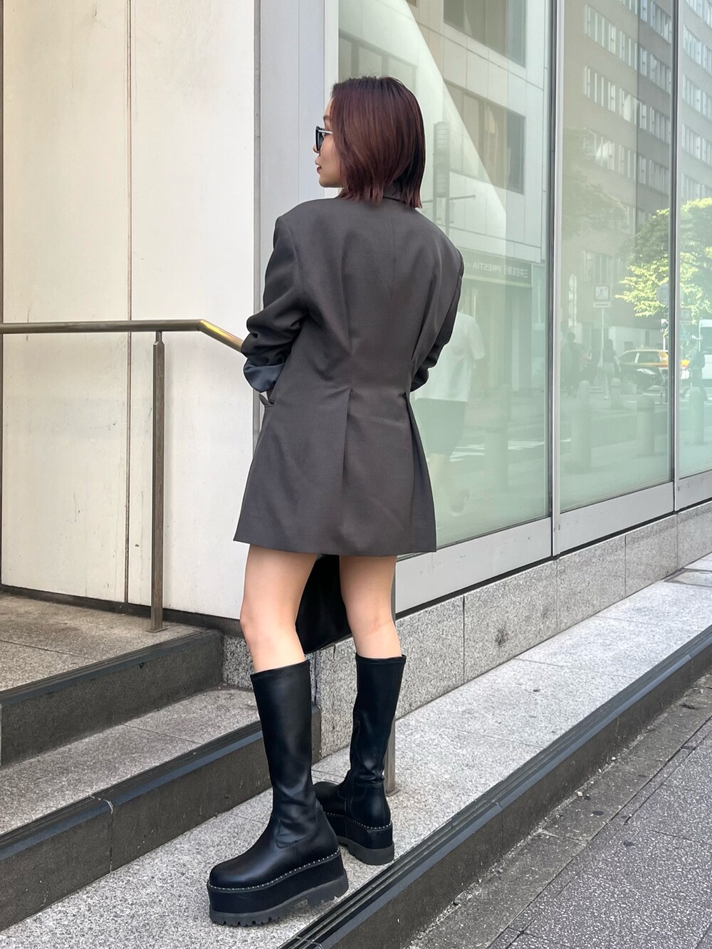 グレー系のテーラードジャケット、グレー系のその他パンツ、ブラック系のニット/セーターを着用したレディースの秋コーディネートの2枚目の写真