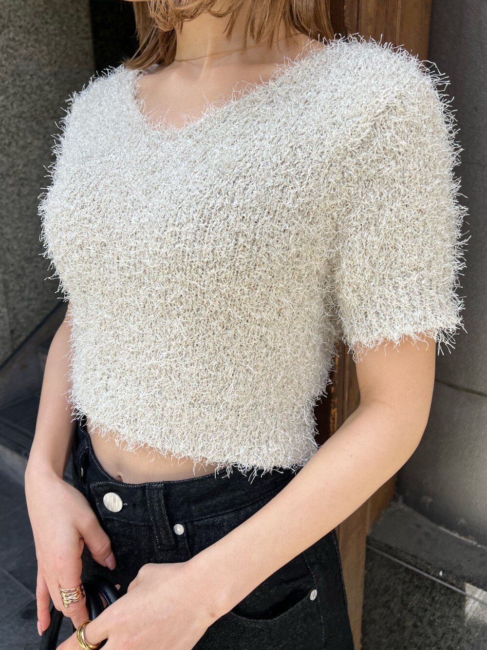 ブラック系のサンダル、ホワイト系のニット/セーター、ブラック系のデニムパンツを着用したレディースの春コーディネートの7枚目の写真
