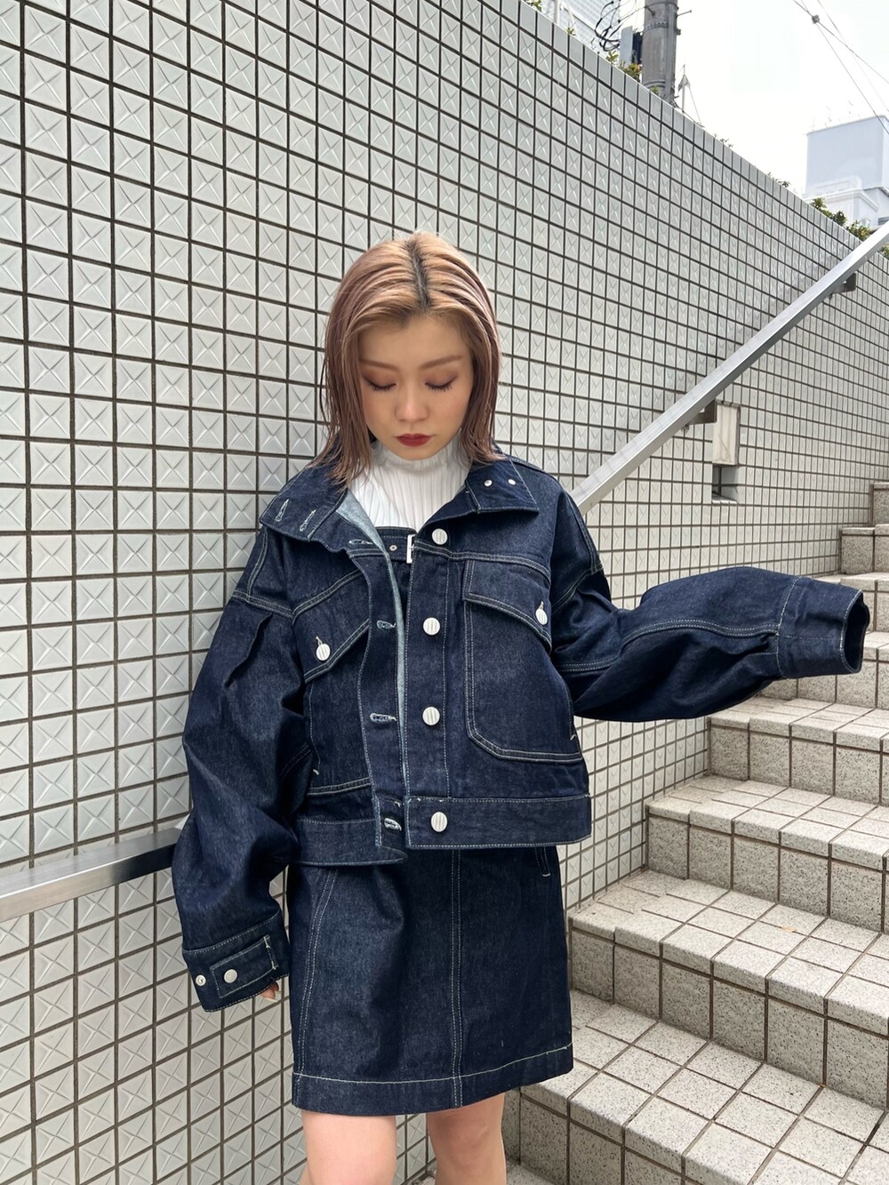 ホワイト系のニット/セーター、ブルー系のワンピース、ブルー系のデニムジャケットを着用したレディースの冬コーディネートの5枚目の写真