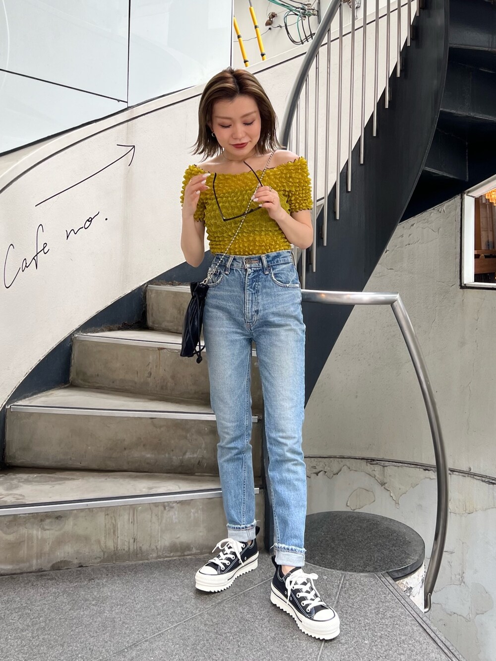 ブラック系のショルダーバッグ、イエロー系のシャツ/ブラウス、ブラック系のサングラスを着用したレディースの春コーディネートの3枚目の写真