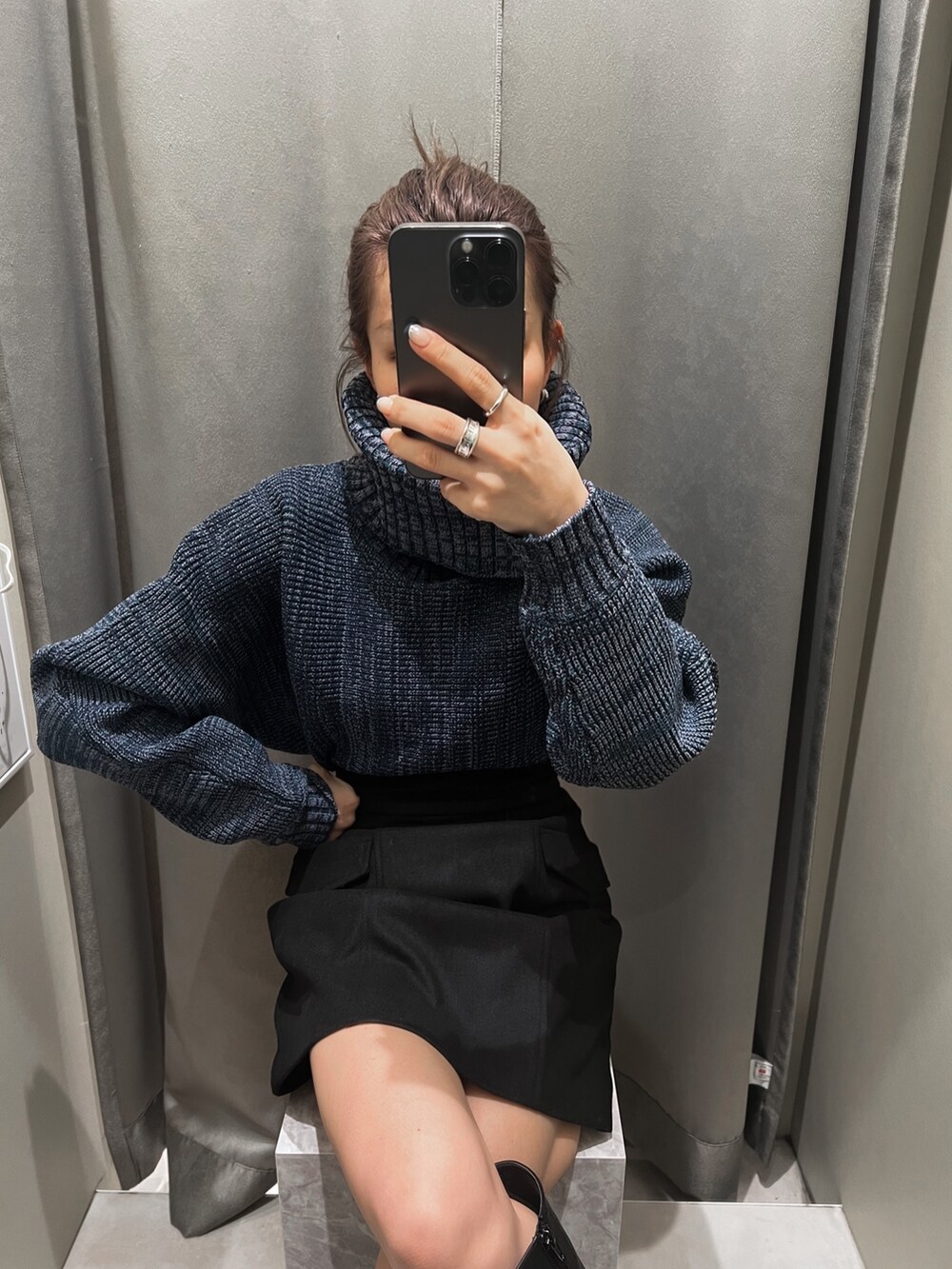 ブラック系のスカート、ブルー系のニット/セーター、ブラック系のブーツを着用したレディースの秋コーディネートの4枚目の写真