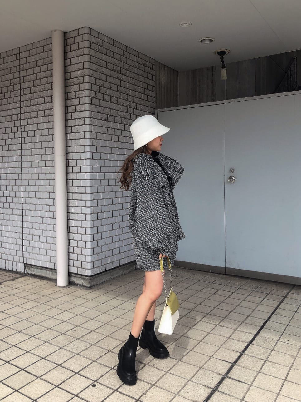 ブラック系のその他アウター、ブラック系のスカート、ブラック系のブーツを着用したレディースの春コーディネートの2枚目の写真