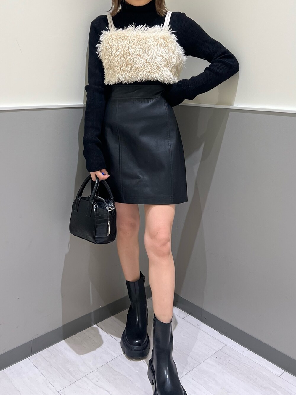 ベージュ系のニット/セーター、ブラック系のニット/セーター、ブラック系のブーツを着用したレディースの冬コーディネートの7枚目の写真