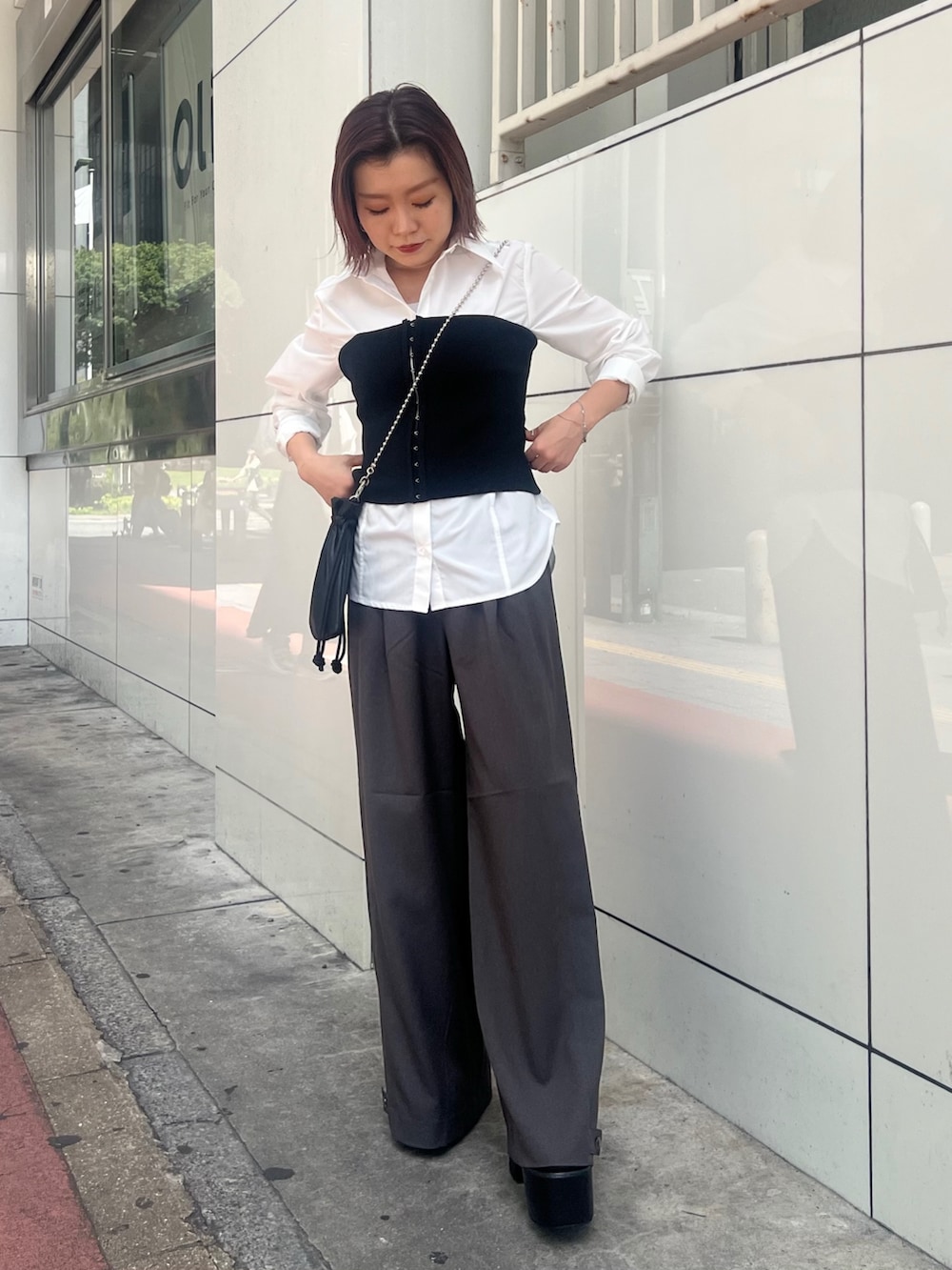 ブラック系のブーツ、ホワイト系のシャツ/ブラウス、ブラック系のニット/セーターを着用したレディースの秋コーディネートの4枚目の写真