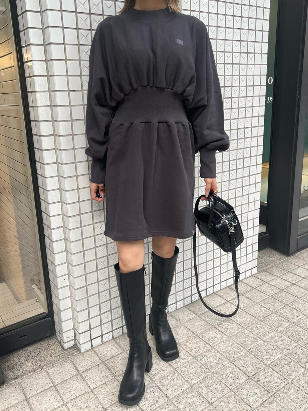 グレー系のワンピース、ブラック系のブーツ、ブラック系のボストンバッグを着用したレディースの夏コーディネートの5枚目の写真