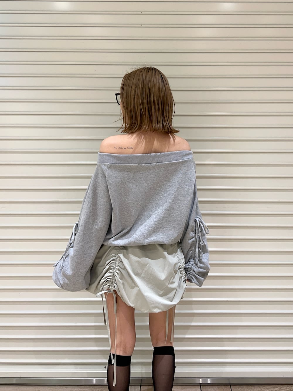 グリーン系のスカート、グレー系のスウェットを着用したレディースの春コーディネートの5枚目の写真