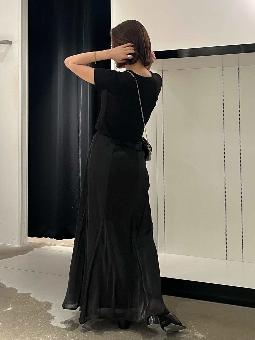 ブラック系のTシャツ/カットソー、ブラック系のスカート、ゴールド系のショルダーバッグを着用したレディースの夏コーディネートの2枚目の写真