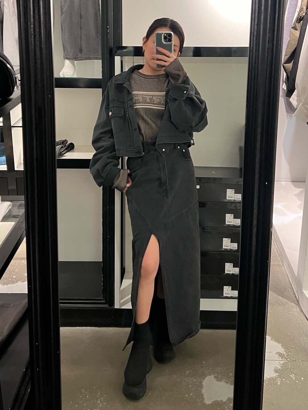 ブラック系のブーツ、ブラック系のデニムスカート、ブラック系のデニムジャケットを着用したレディースの春コーディネートの4枚目の写真