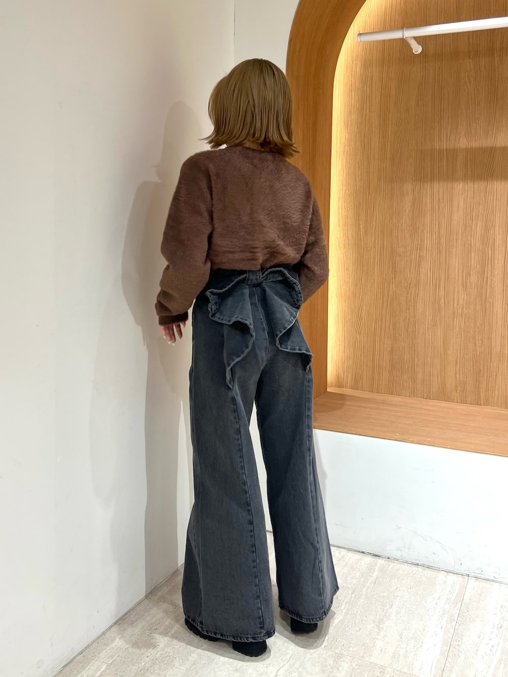 ブラウン系のカーディガン/ボレロ、ブラック系のデニムパンツ、ブラウン系のブーツを着用したレディースの冬コーディネートの3枚目の写真