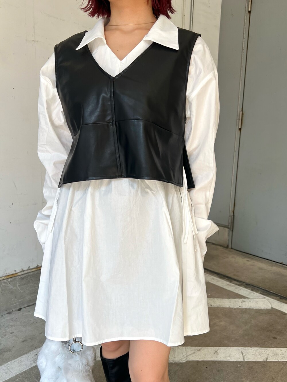 ベージュ系のハンドバッグ、ブラック系のワンピース、ブラック系のブーツを着用したレディースの秋コーディネートの7枚目の写真