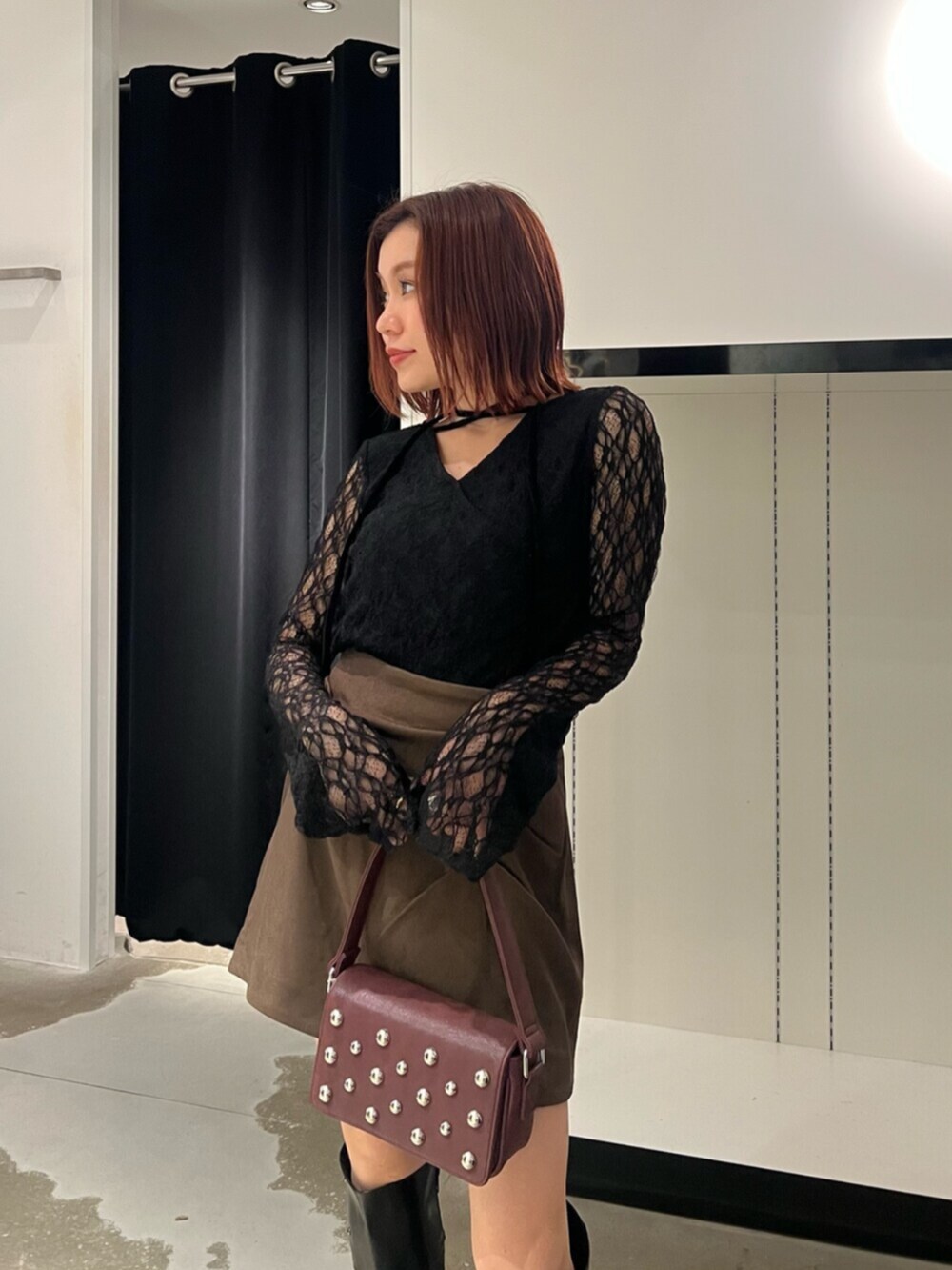 ブラック系のTシャツ/カットソー、ブラウン系のスカート、ブラック系のブーツを着用したレディースの秋コーディネートの5枚目の写真