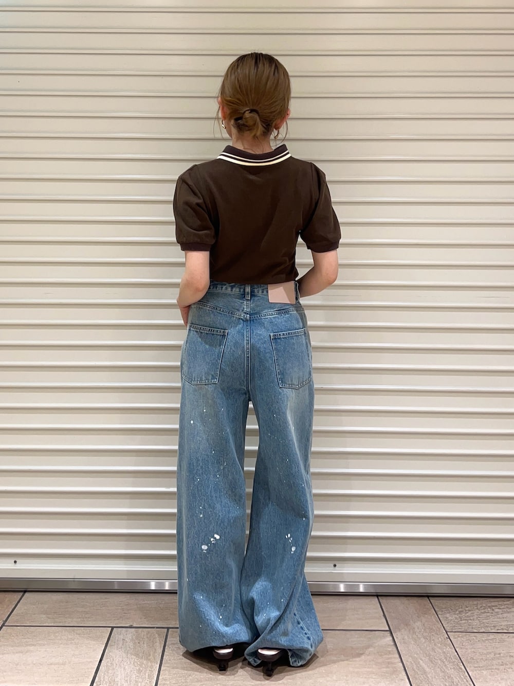 ブルー系のデニムパンツ、ブラウン系のサンダル、ブラウン系のTシャツ/カットソーを着用したレディースの春コーディネートの3枚目の写真