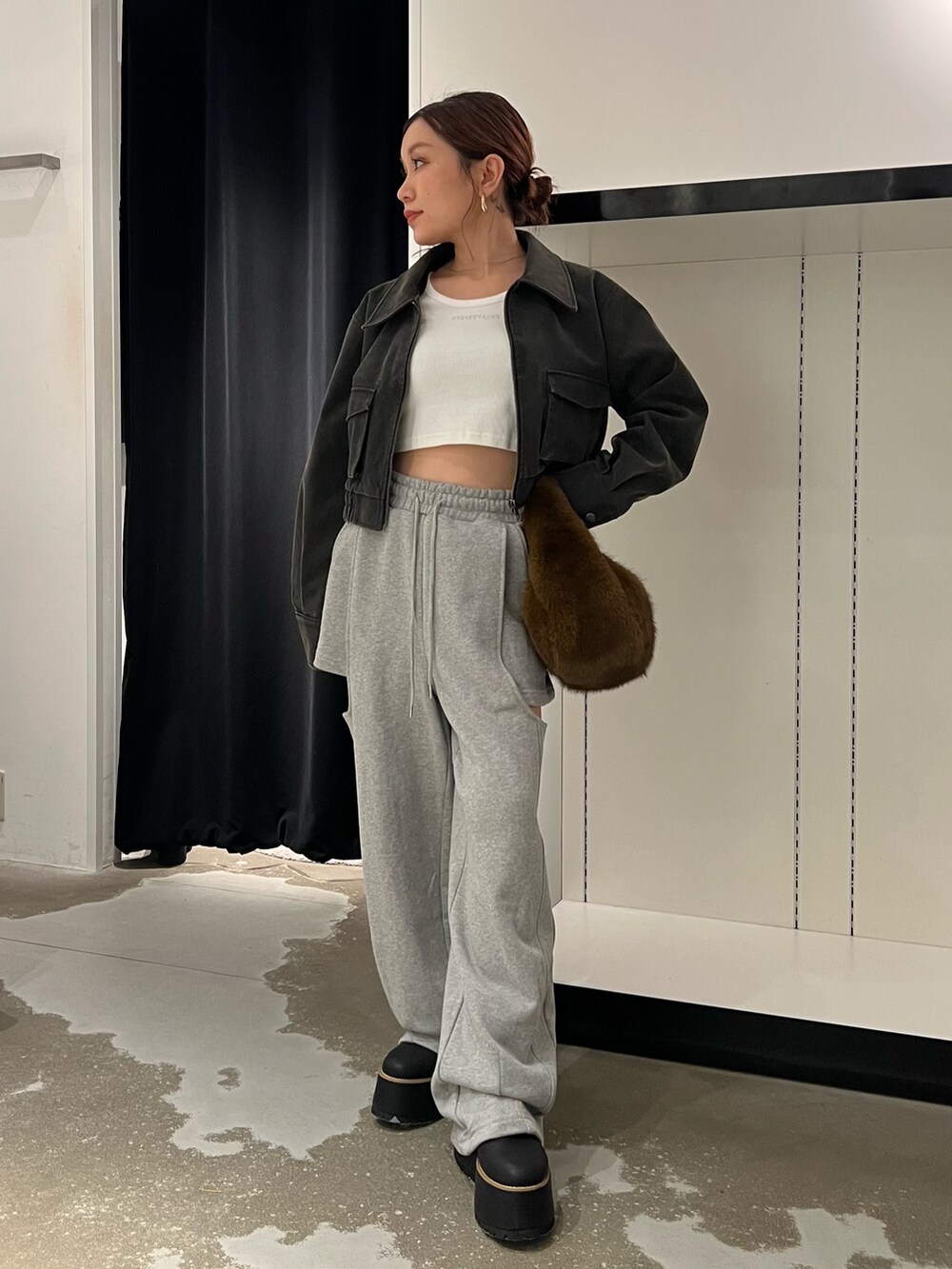 ブラック系のブルゾン、ホワイト系のTシャツ/カットソー、グレー系のスウェットパンツを着用したレディースの秋コーディネートの4枚目の写真