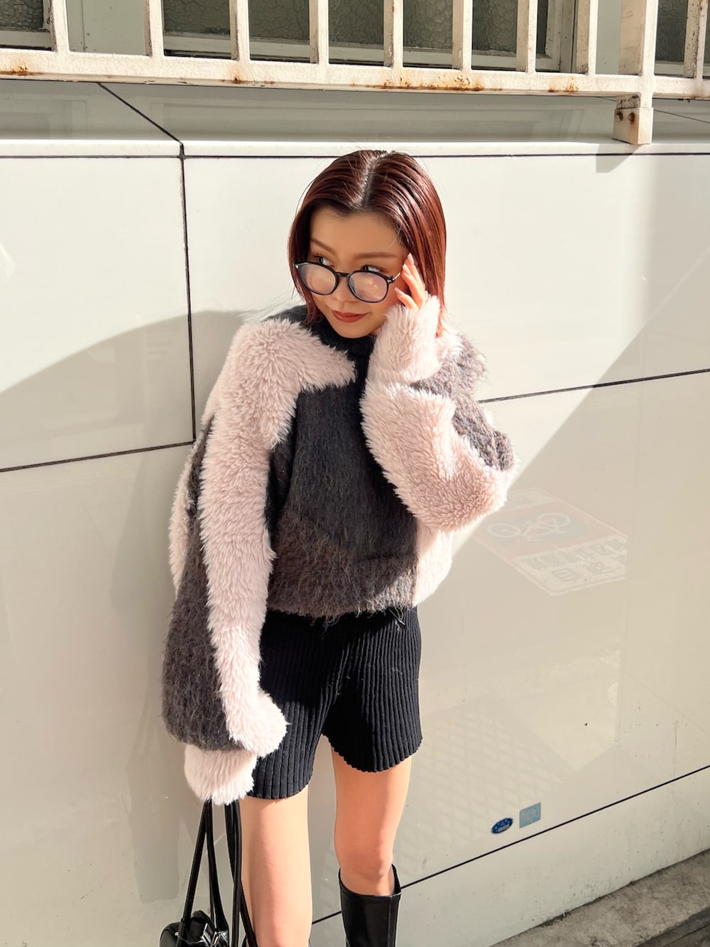 ブラック系のその他パンツ、ブラック系のボストンバッグ、ブラック系のブーツを着用したレディースの冬コーディネートの6枚目の写真