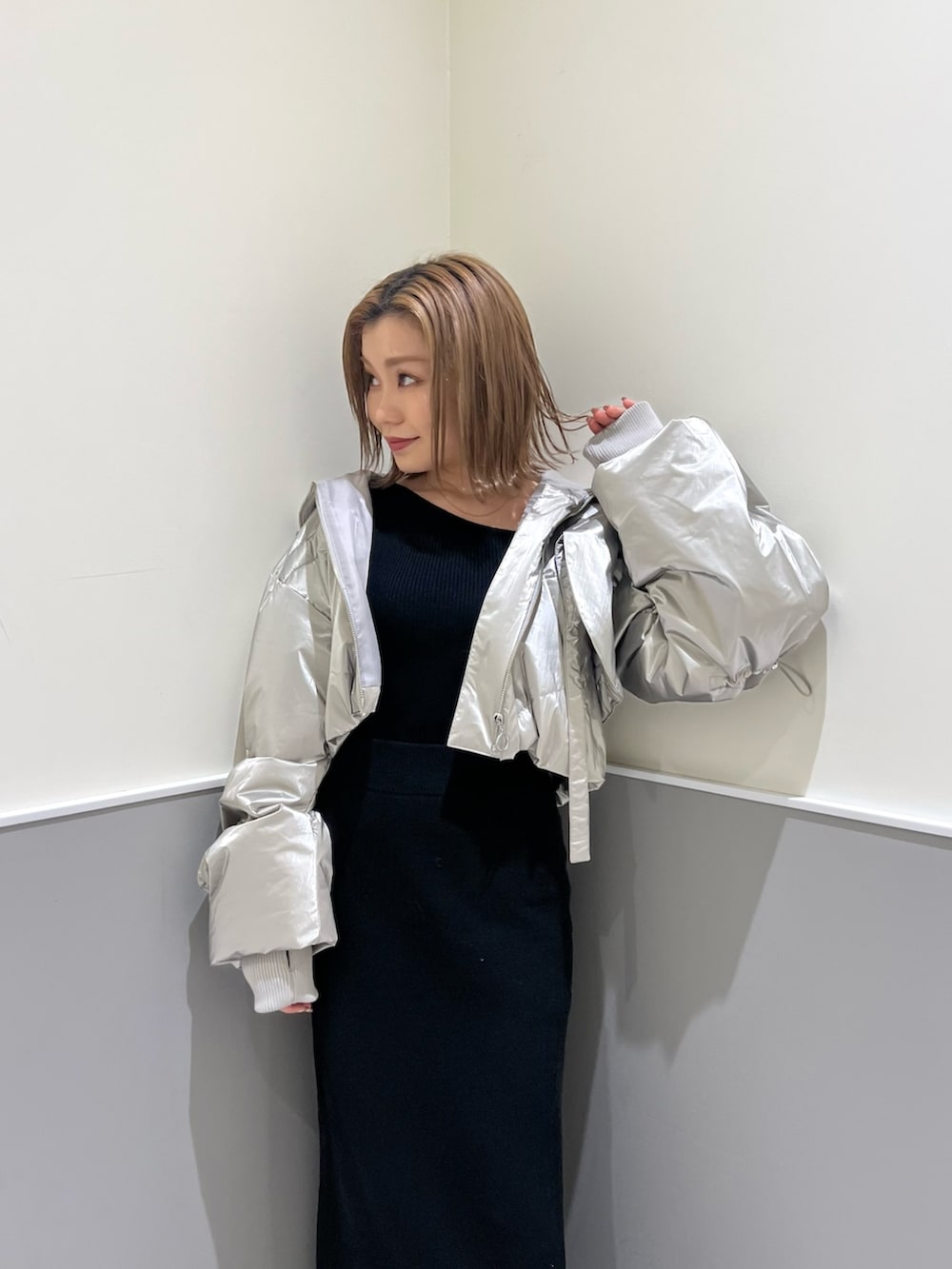 ブラック系のニット/セーター、シルバー系のブルゾン、ブラック系のスカートを着用したレディースの冬コーディネートの5枚目の写真