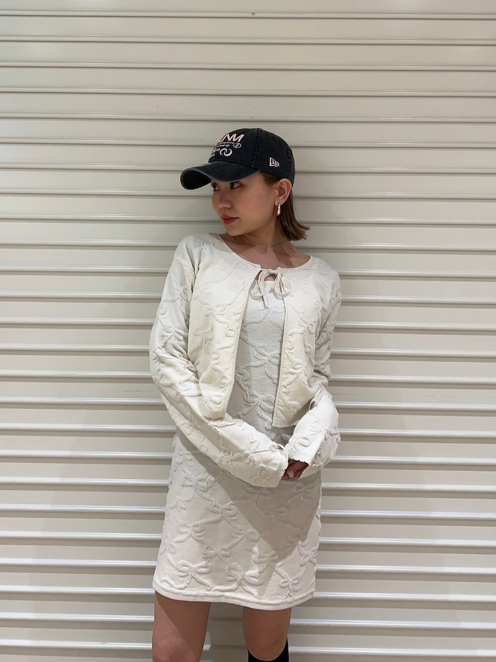 ホワイト系のワンピース、ホワイト系のカーディガン/ボレロ、ブラック系のキャップを着用したレディースの冬コーディネートの4枚目の写真