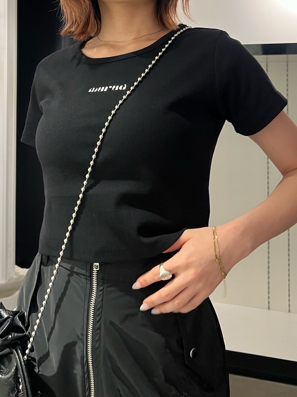 ブラック系のTシャツ/カットソー、ブラック系のサンダル、ブラック系のスカートを着用したレディースの春コーディネートの6枚目の写真