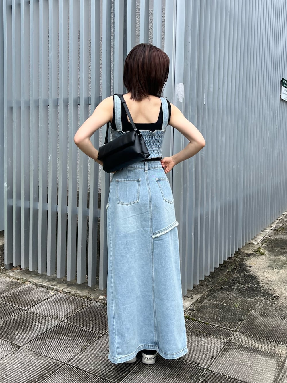 ブルー系のシャツ/ブラウス、ブルー系のデニムスカート、ブラック系のニット/セーターを着用したレディースの夏コーディネートの4枚目の写真