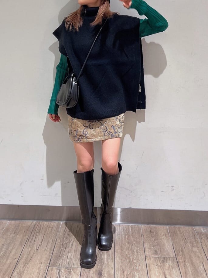 ブラック系のブーツ、グリーン系のニット/セーター、ブラウン系のスカートを着用したレディースの秋コーディネートの6枚目の写真