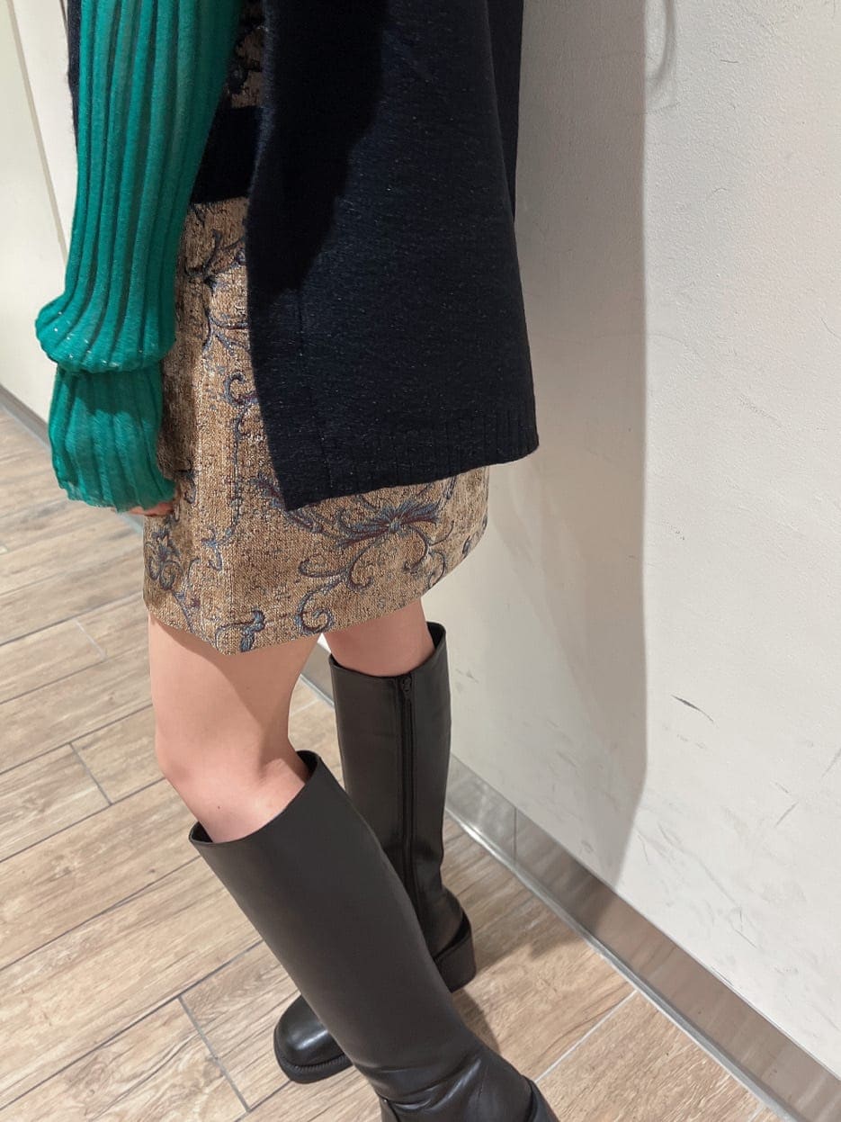 ブラック系のブーツ、グリーン系のニット/セーター、ブラウン系のスカートを着用したレディースの秋コーディネートの8枚目の写真