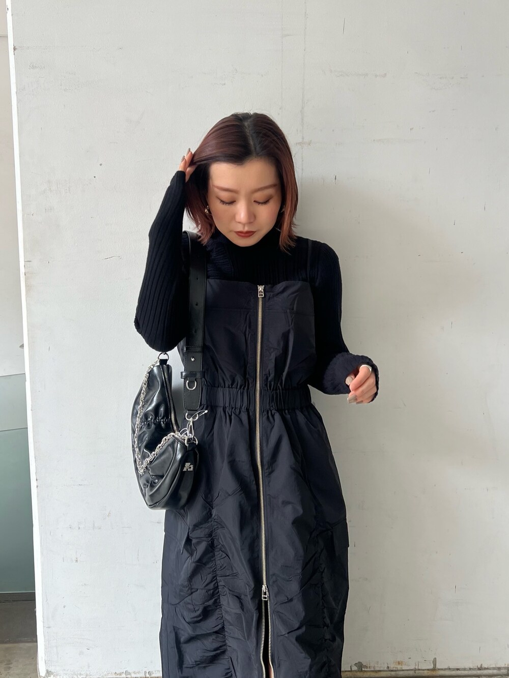 ブラック系のワンピース、ブラック系のブーツ、ブラック系のニット/セーターを着用したレディースの冬コーディネートの6枚目の写真