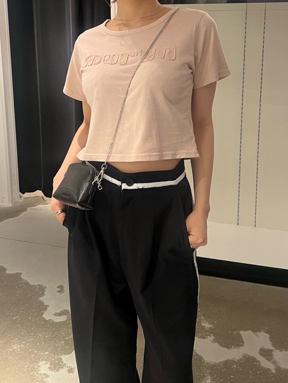 ブラック系のその他パンツ、ブラック系のショルダーバッグ、ピンク系のTシャツ/カットソーを着用したレディースの夏コーディネートの6枚目の写真