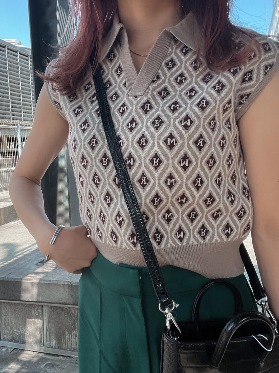 ベージュ系のニット/セーター、グリーン系のスラックスを着用したレディースの夏コーディネートの6枚目の写真