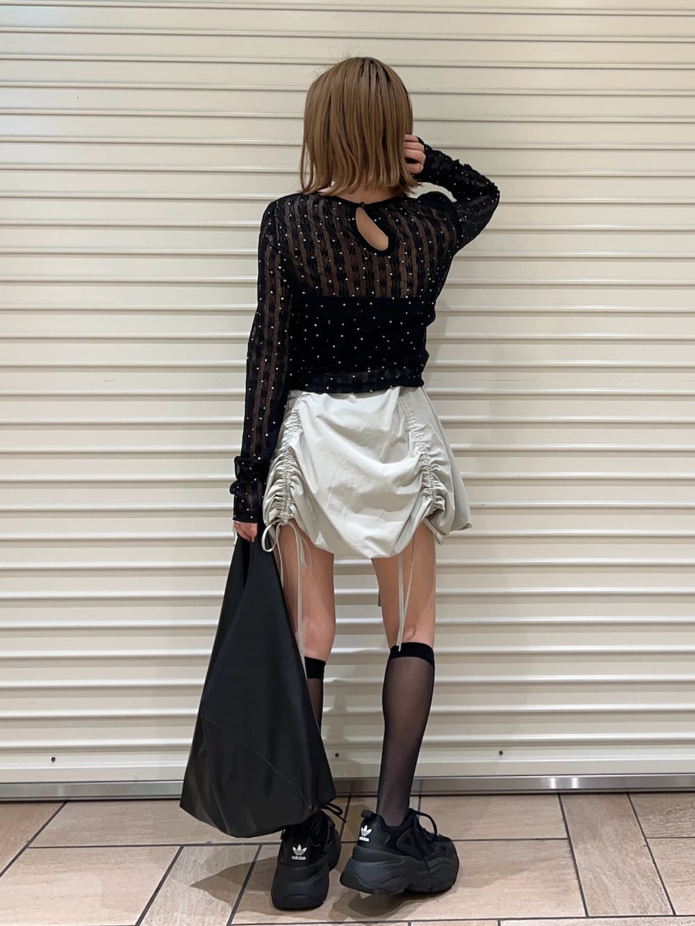 ブラック系のTシャツ/カットソー、グリーン系のスカートを着用したレディースの春コーディネートの3枚目の写真