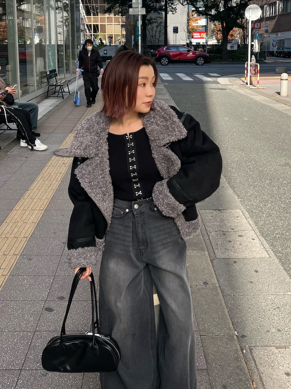 グレー系のデニムパンツ、ブラック系のニット/セーター、ブラック系のブーツを着用したレディースの冬コーディネートの5枚目の写真